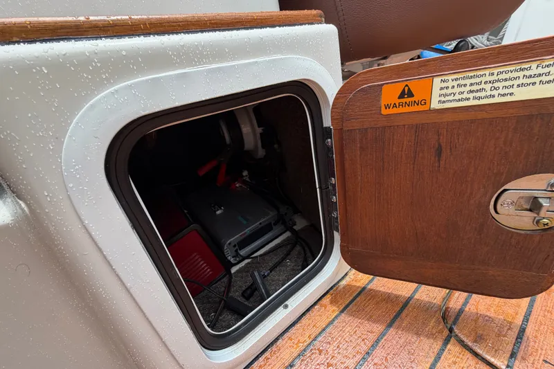 Slide: The Image of Open storage compartment on 2005 Chris-Craft Corsair 25 boat with warning label. - 43