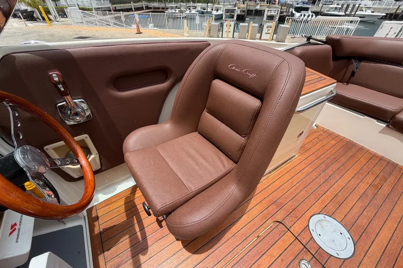 Slide: The Image of 2005 Chris-Craft Corsair 25 boat interior with brown leather seating and wooden flooring. - 35