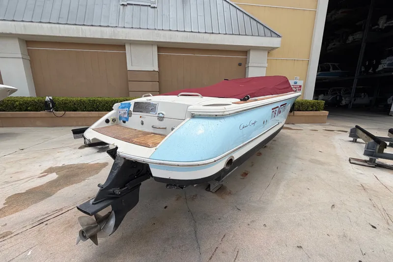 Slide: The Image of 2005 Chris-Craft Corsair 25 boat with red cover, parked outdoors. - 17