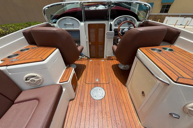 Slide: The Image of 2005 Chris-Craft Corsair 25 boat interior with wooden deck and leather seating. - 30