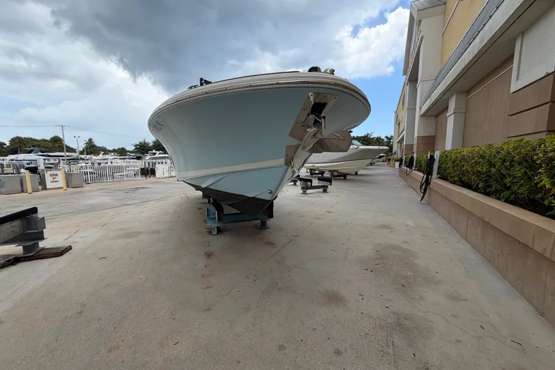Slide: The Image of 2005 Chris-Craft Corsair 25 boat on trailer, parked outdoors under cloudy sky. - 4
