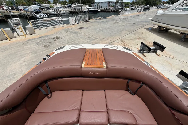 Slide: The Image of 2005 Chris-Craft Corsair 25 boat with brown leather seating at a marina. - 22