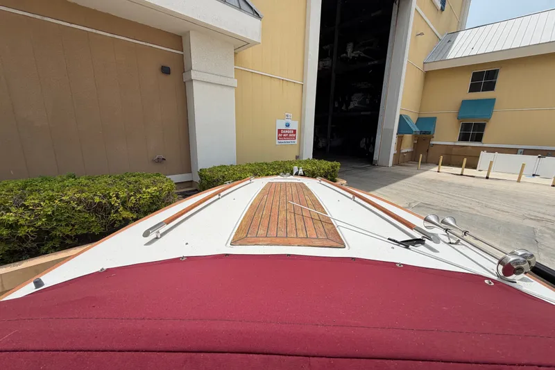 Slide: The Image of 2005 Chris-Craft Corsair 25 boat docked near a storage facility entrance. - 28