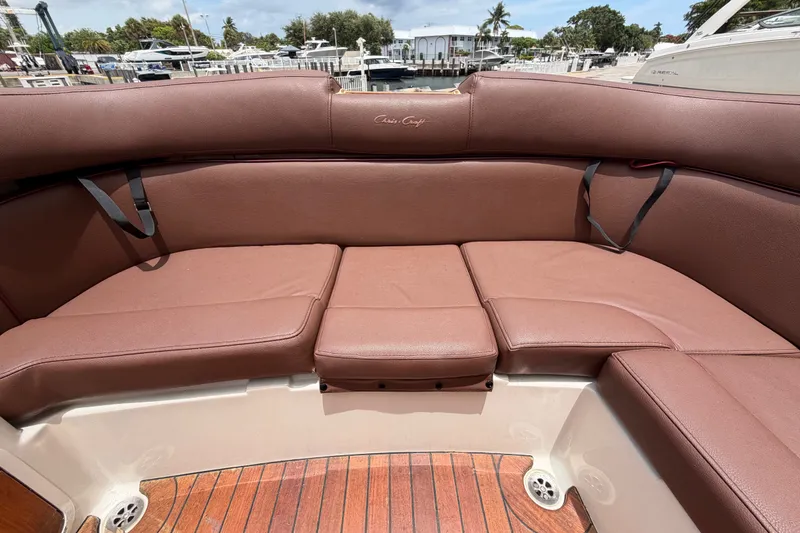 Slide: The Image of 2005 Chris-Craft Corsair 25 boat interior with brown leather seating and wooden deck. - 20