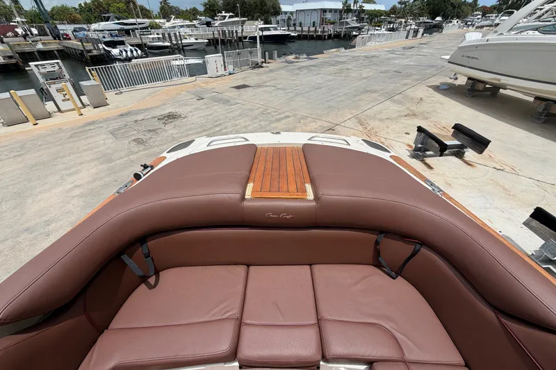 Slide: The Image of 2005 Chris-Craft Corsair 25 boat with brown leather seating at a marina. - 21