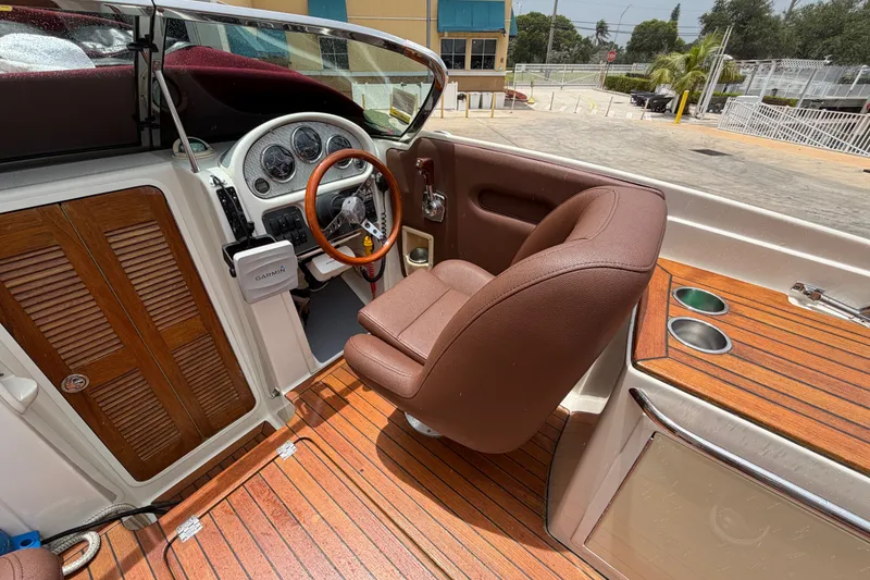 Slide: The Image of 2005 Chris-Craft Corsair 25 cockpit with wooden accents and brown leather seating. - 32