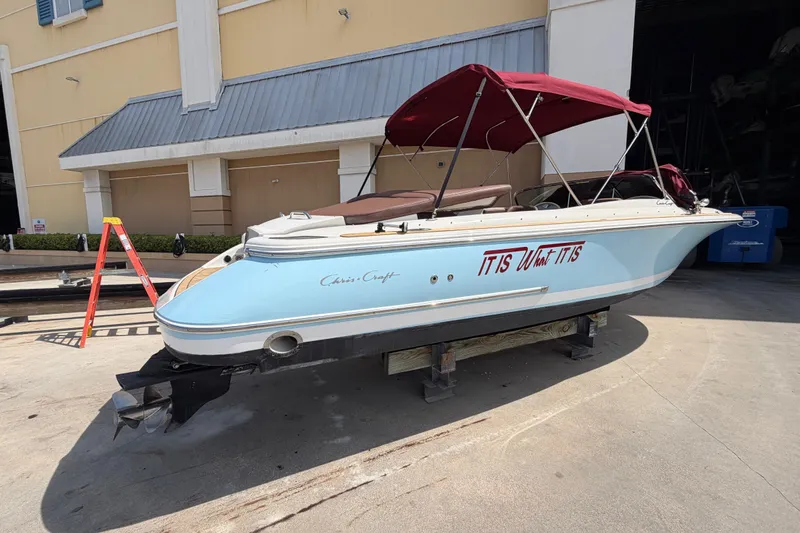 Slide: The Image of 2005 Chris-Craft Corsair 25 boat with red canopy, docked outdoors. - 17