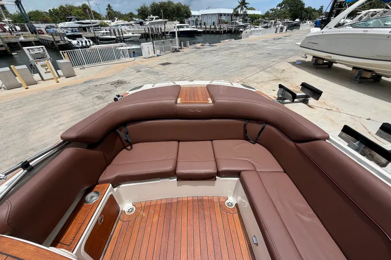 Slide: The Image of 2005 Chris-Craft Corsair 25 boat interior with brown leather seating and wooden deck. - 18
