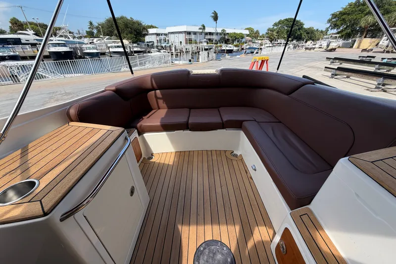 Slide: The Image of 2005 Chris-Craft Corsair 25 boat interior with brown leather seating and wooden deck. - 24