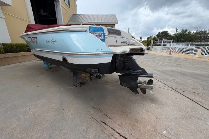 Slide: The Image of 2005 Chris-Craft Corsair 25 boat on dry dock, showcasing stern and propeller. - 12