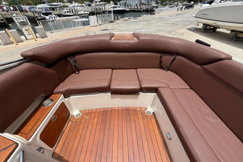 Slide: The Image of 2005 Chris-Craft Corsair 25 boat interior with brown leather seating and wooden flooring. - 19