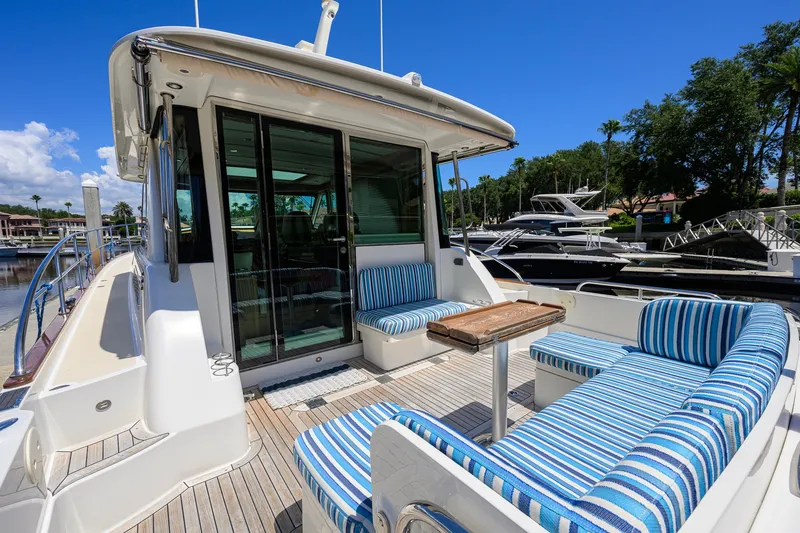 Slide: The Image of 2018 Sabre 45 Salon Express yacht with striped seating, docked under a clear blue sky. - 48