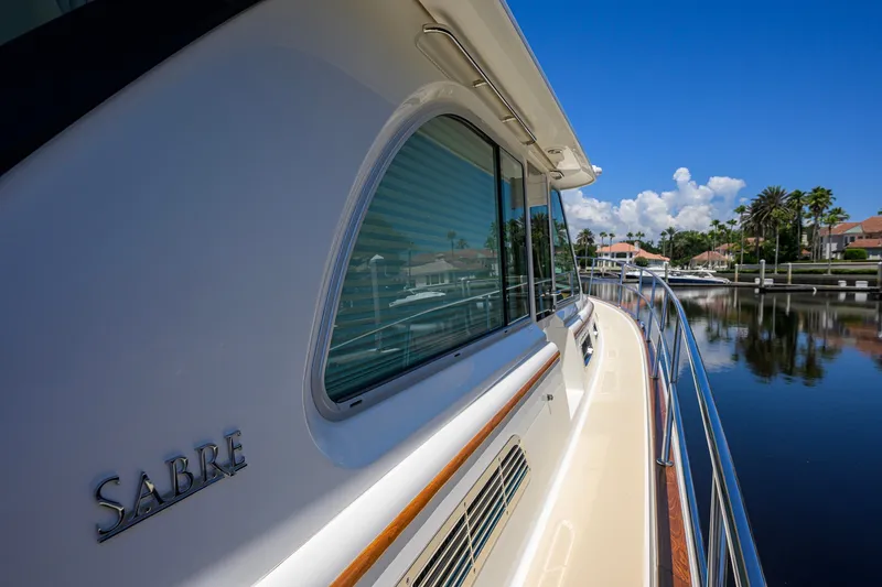 Slide: The Image of 2018 Sabre 45 Salon Express yacht docked by waterfront homes under clear blue sky. - 71