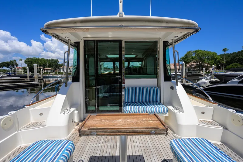 Slide: The Image of 2018 Sabre 45 Salon Express yacht with striped seating at a marina. - 50