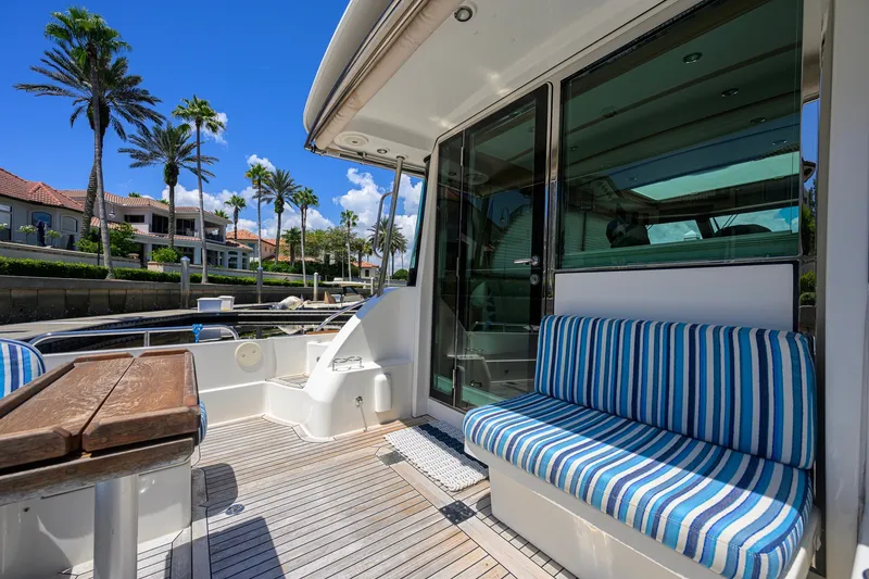 Slide: The Image of 2018 Sabre 45 Salon Express yacht deck with striped seating and waterfront view. - 51
