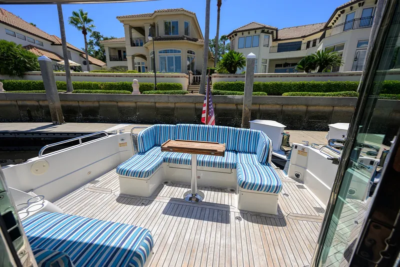 Slide: The Image of Luxury yacht deck with striped seating, Sabre 45 Salon Express 2018, docked near waterfront homes. - 54