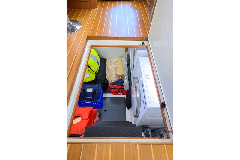 Slide: The Image of Storage compartment in 2018 Sabre 45 Salon Express with life jackets and washer. - 56