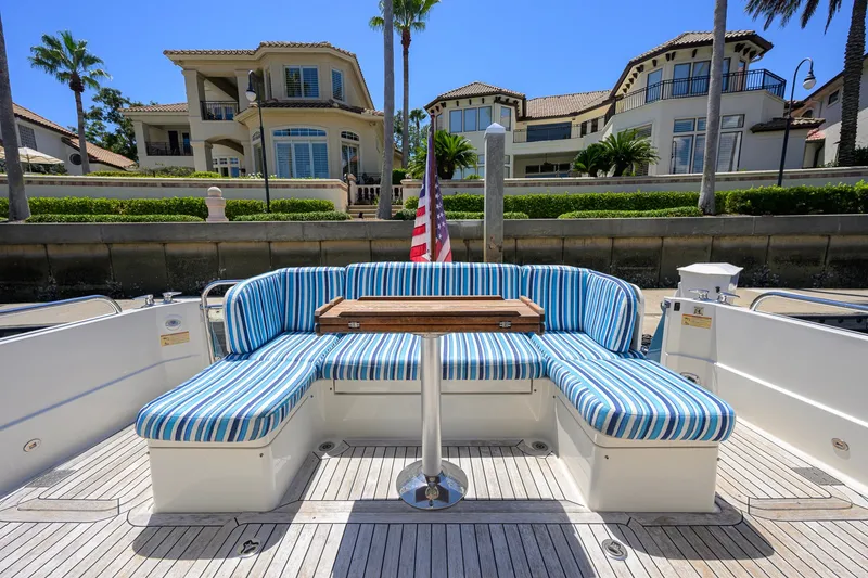 Slide: The Image of 2018 Sabre 45 Salon Express yacht with striped seating, docked near luxury waterfront homes. - 53
