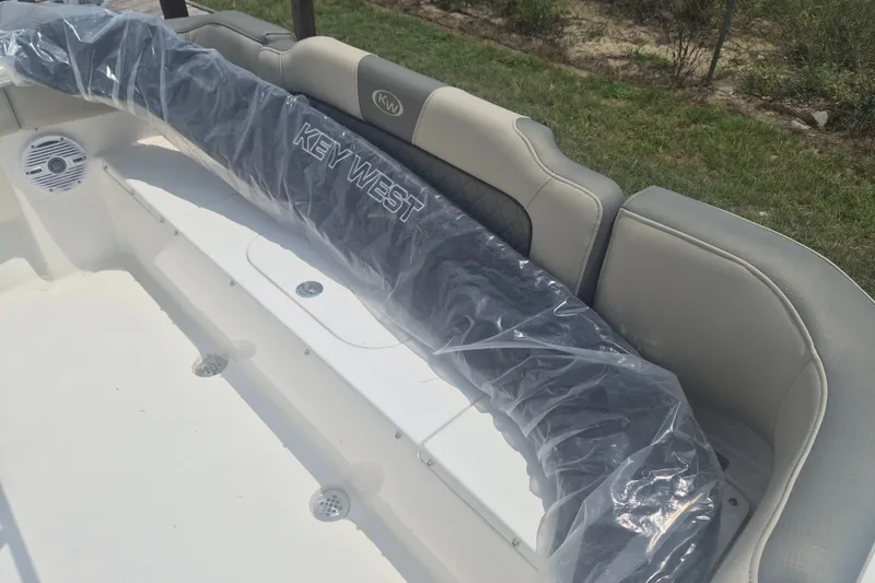 Slide: The Image of 2026 Key West 203 FS boat interior with cushioned seating and protective cover. - 6