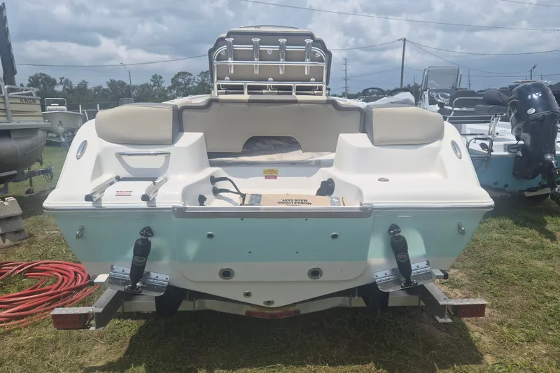Slide: The Image of 2026 Key West 203 FS boat rear view, parked on grass under cloudy sky. - 3