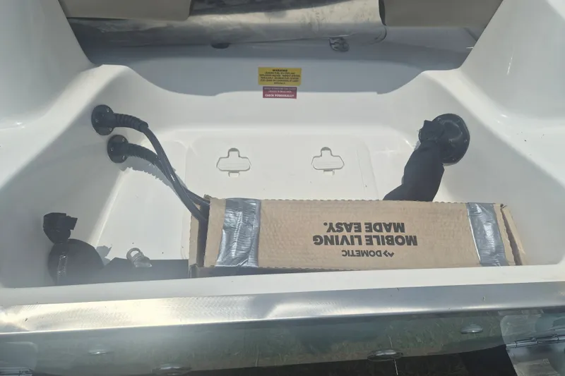 Slide: The Image of Storage compartment of 2026 Key West 203 FS boat with cables and cardboard box. - 5