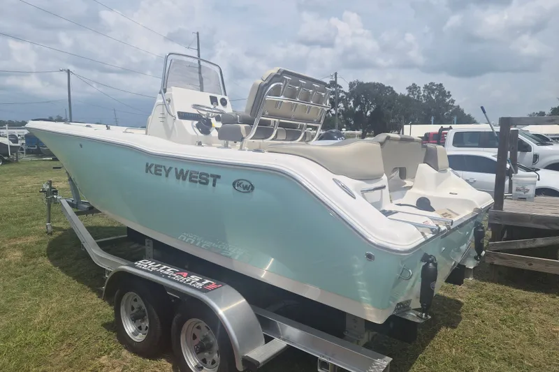 Slide: The Image of 2026 Key West 203 FS boat on trailer, displayed outdoors on grass. - 2