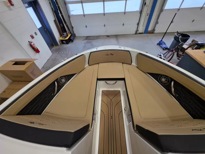 Slide: The Image of The image shows the bow area of a Sea Ray SPX 210 boat with beige upholstery. - 19