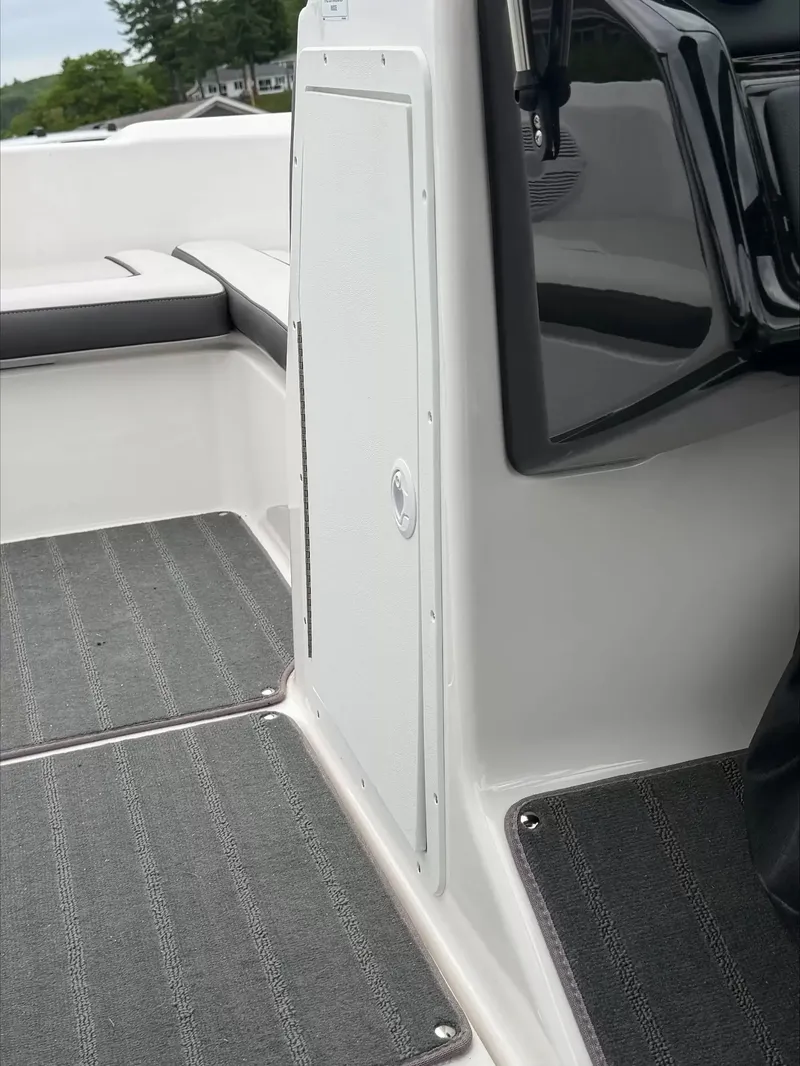 Slide: The Image of The image shows the interior of a Sea Ray SPX 210 boat with gray carpeting. - 21