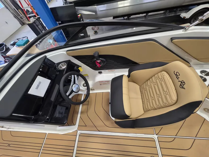 Slide: The Image of The image shows the cockpit of a Sea Ray SPX 210 boat with a sleek steering wheel and beige seat. - 14