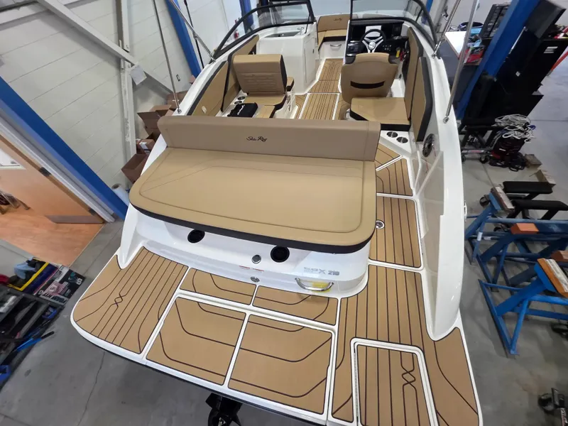 Slide: The Image of The image shows a 2027 Sea Ray SPX 210 boat with a spacious deck and beige upholstery. - 9