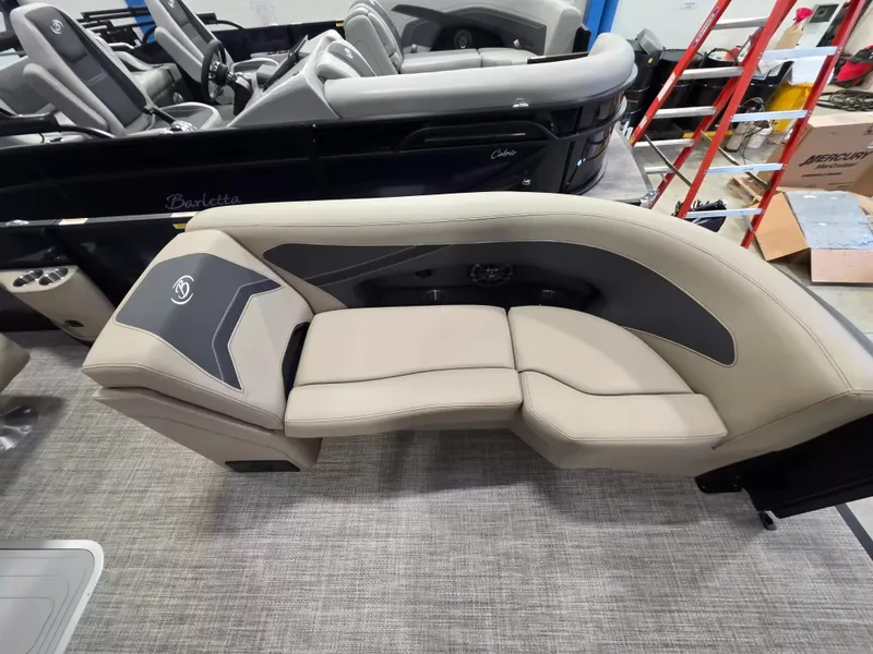 Slide: The Image of The image shows a luxurious beige upholstered seat on a Barletta ARIA 22UC boat. - 23