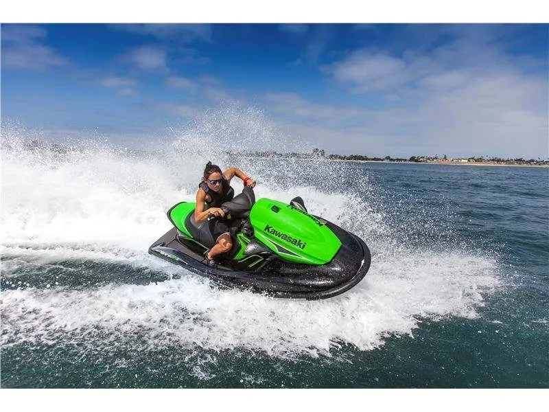 Slide: The Image of A person rides a green Kawasaki jet ski on the water, creating a spray of mist. - 8