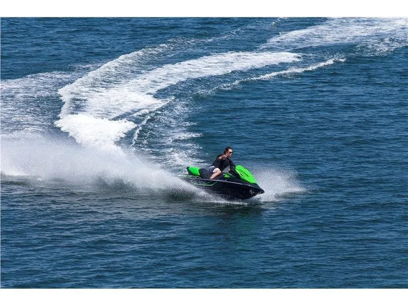 Slide: The Image of A man rides a green Kawasaki Jet Ski STX-15F on open water. - 10