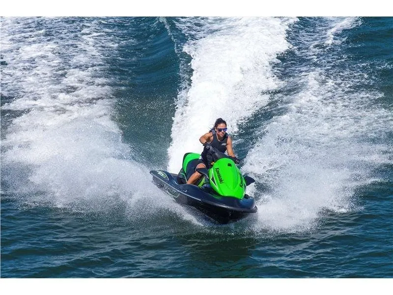 Slide: The Image of A person rides a green Kawasaki Jet Ski STX-15F on the water, creating a splash. - 9