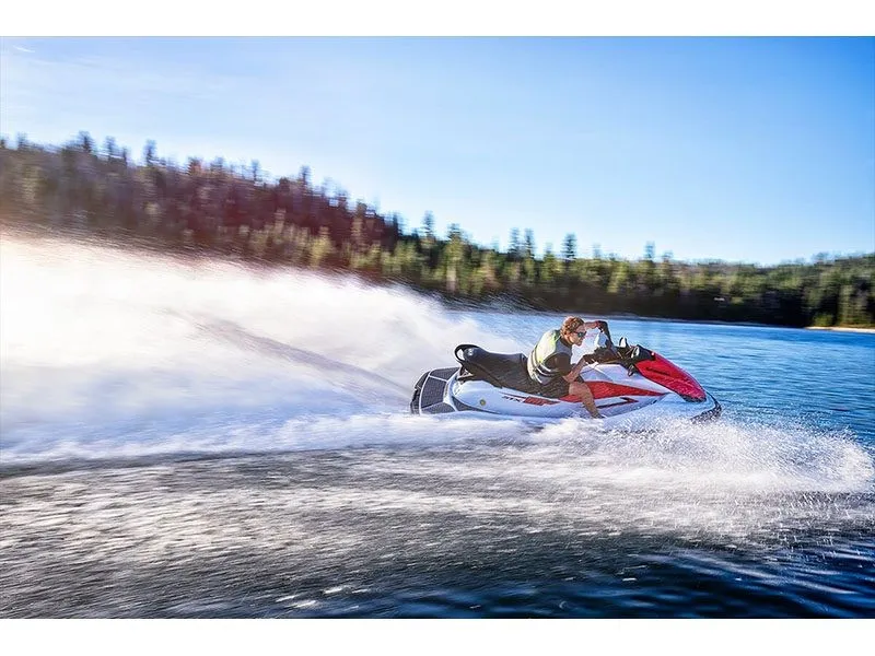 Slide: The Image of A 2021 Kawasaki JET SKI STX 160 speeding across a lake, surrounded by trees. - 7