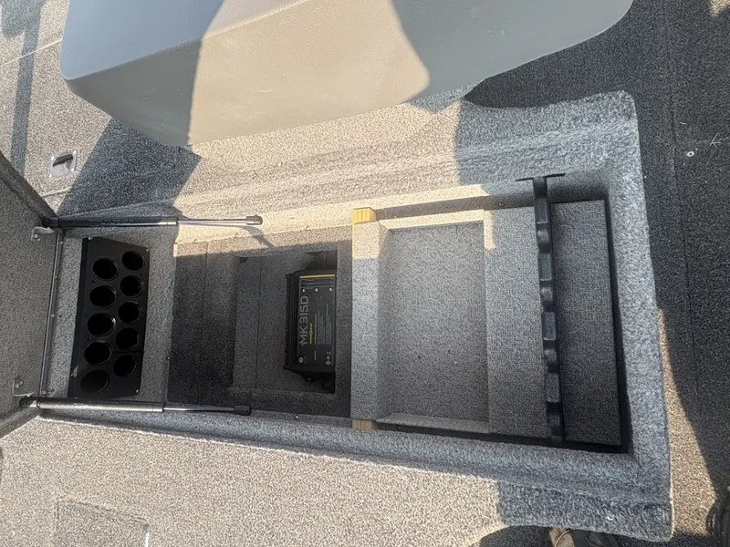 Slide: The Image of An open storage compartment on a carpeted boat with a battery compartment. - 14