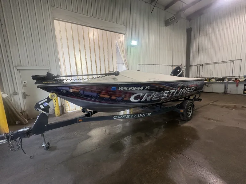 Slide: The Image of A 2014 Crestliner 1850 Fish Hawk on a trailer inside a warehouse. - 7
