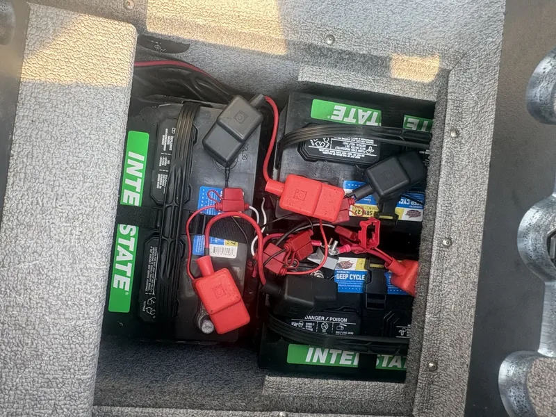 Slide: The Image of A battery compartment with multiple car batteries and cables, installed in a boat. - 15