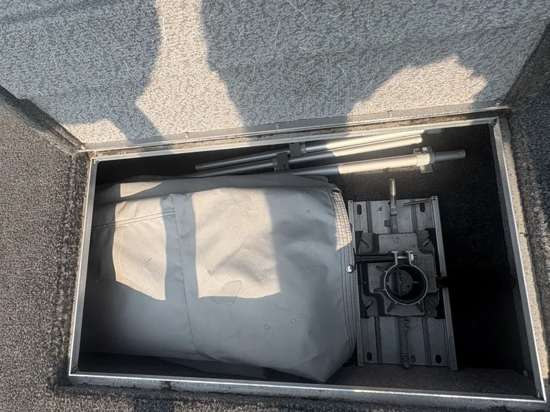 Slide: The Image of A storage compartment in the boat with a cover and metal rods. - 12