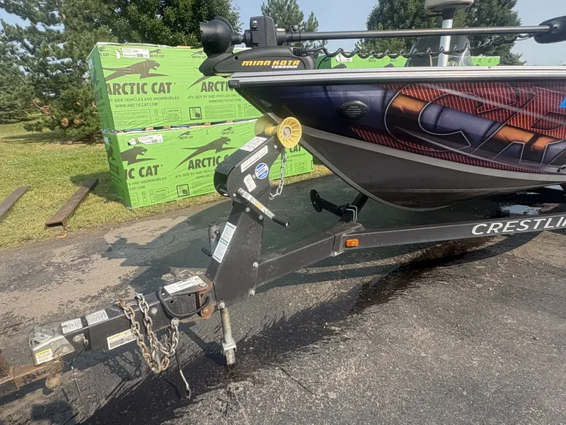 Slide: The Image of A 2014 Crestliner 1850 Fish Hawk boat on a trailer, surrounded by green boxes. - 5