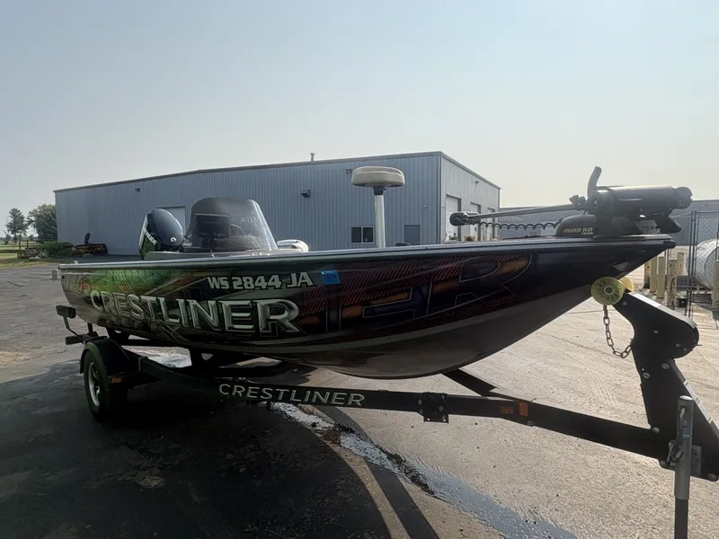 Slide: The Image of A 2014 Crestliner 1850 Fish Hawk on a trailer, parked in front of a building. - 4
