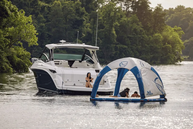 Slide: The Image of A 2027 Sea Ray Sundancer 320 anchored on a calm lake beside a floating tent. - 48