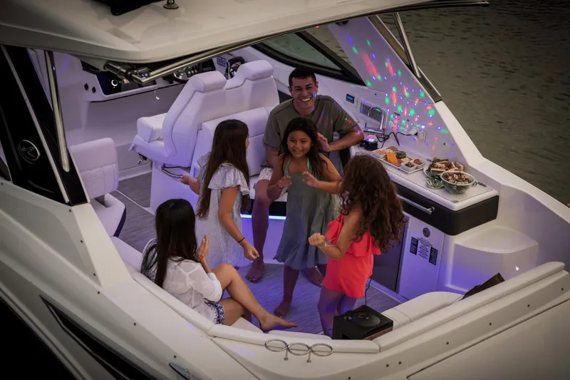 Slide: The Image of A group of people dancing and laughing on a Sea Ray Sundancer 320 boat. - 39