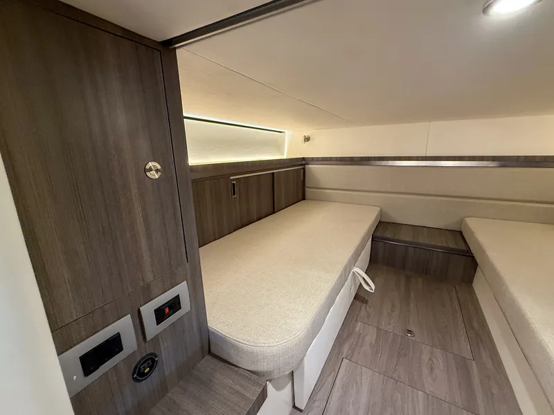 Slide: The Image of Interior of the 2027 Sea Ray Sundancer 320 Outboard with two cushioned berths and wooden walls. - 25