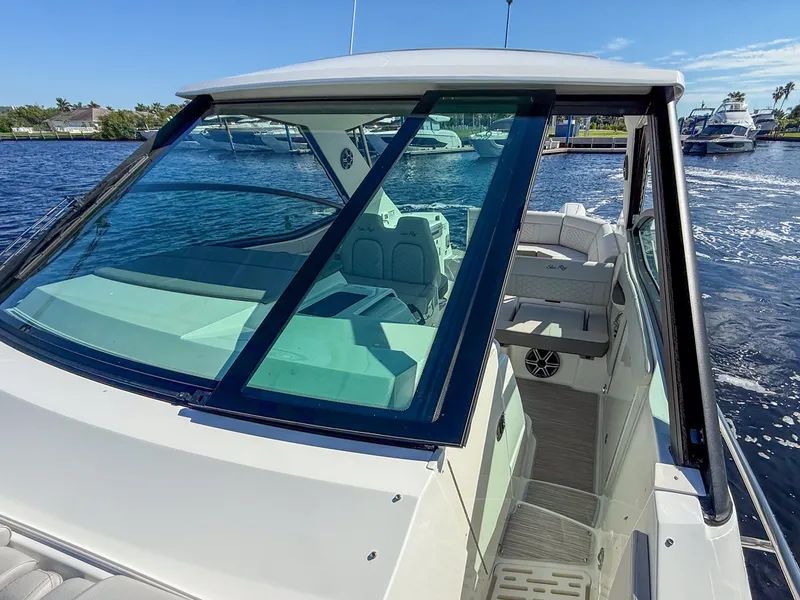 Slide: The Image of The 2027 Sea Ray Sundancer 320 Outboard is docked on the water. It features a modern design with large windows. - 16