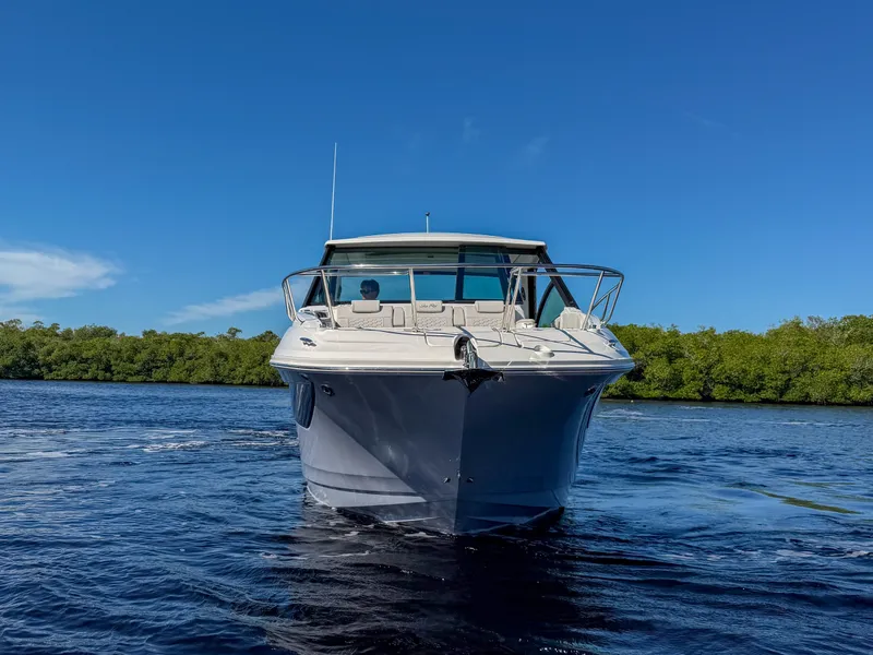 Slide: The Image of The 2027 Sea Ray Sundancer 320 Outboard cruises on calm water under a clear blue sky. - 27