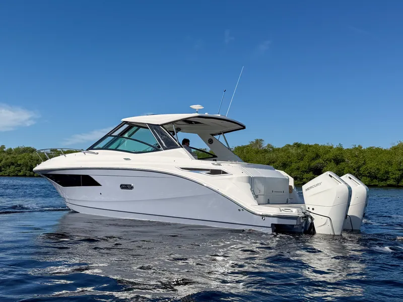 Slide: The Image of A 2027 Sea Ray Sundancer 320 Outboard on calm water with two outboard engines. - 31