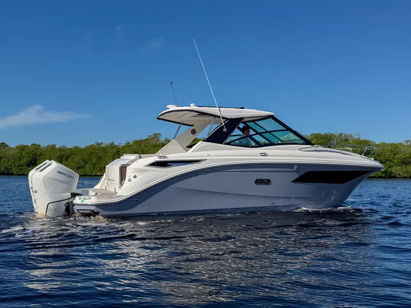 Slide: The Image of 2027 Sea Ray Sundancer 320 Outboard on calm water with a blue sky in the background. - 29