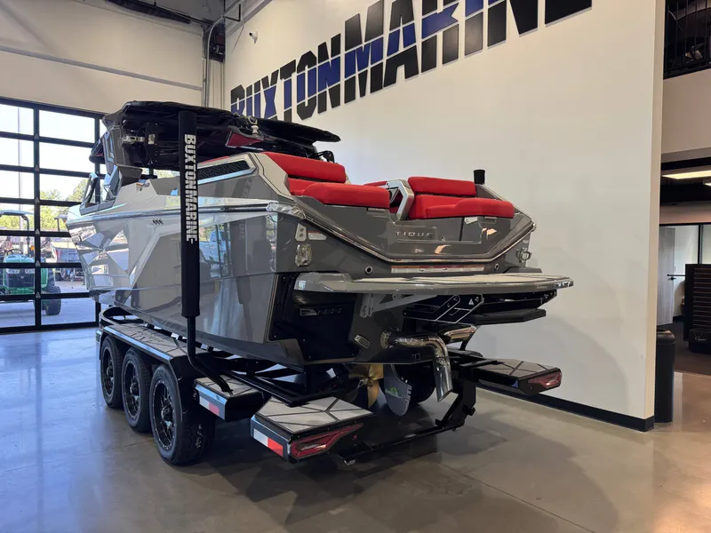 Slide: The Image of A luxury motorboat with a gray hull and red seats sits on a trailer in a showroom. - 5