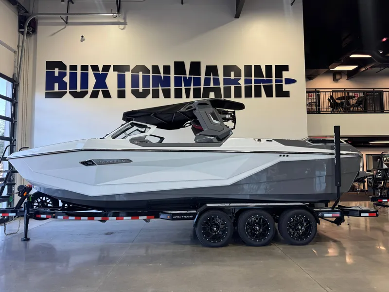 Slide: The Image of A sleek, modern boat with a gray hull sits on a trailer in a showroom. - 4